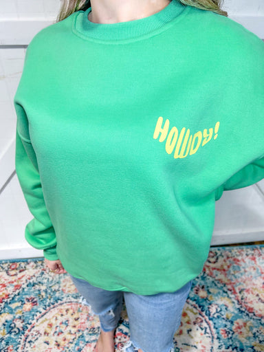 Close up of our green sweatshirt saying Howdy on the front frocket area