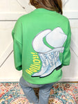 Woman modeling the back of our green sweatshirt showing a cowboy boot and saying Howdy big on the back