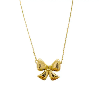 Up close photo of a big gold bow at the center of this necklace