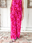 Woman modeling the matching red with magenta flowers all over pants to this matching pants set