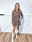 Woman wearing a short brown corduroy dress with white cowboy boots