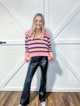 Woman modeling a dusty pink with black stripes sweater with a V-neck and wide collar and sleeves