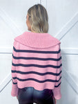 Woman modeling the back of a dusty pink with black stripes sweater with a V-neck and wide collar and sleeves