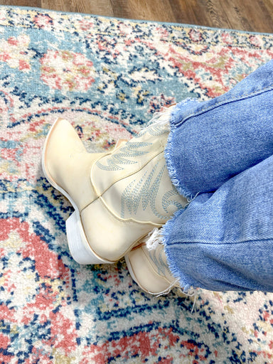 Photo of cream western booties with light blue stitching