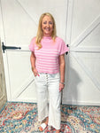 Model wearing a light pink sweater top with white stripes