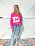 woman modeling our magenta Texas sweatshirt with large white bold letters saying TEXAS across the front