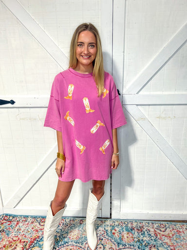 woman modeling a pink t-shirt dress with pockets and has cowboy boots all over