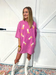 Another photo of a woman modeling a pink t-shirt dress with pockets and has cowboy boots all over