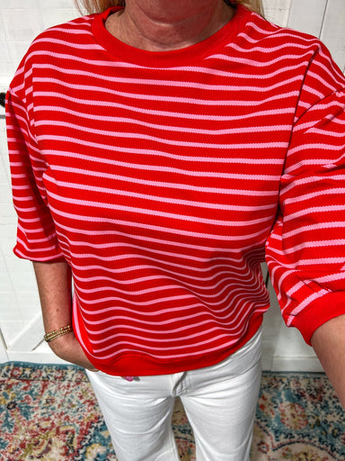 Up close photo of our Sweet Top that is red 3/4 bubble sleeve top with horizontal light pink stripes