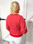 model showcasing the back of this red 3/4 bubble sleeve top with horizontal light pink stripes