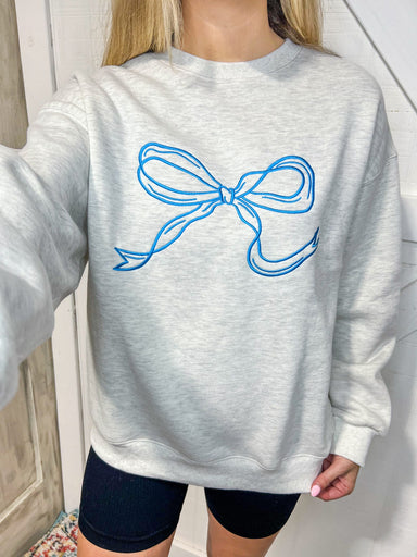 Up close photo of our light grey sweatshirt with a big bow on the front in turquoise blue