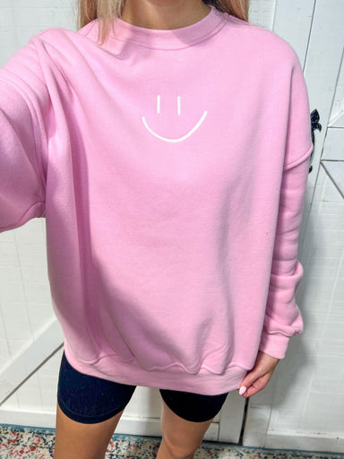 Up close photo of the smiley face embroidered on the front