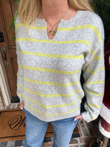 Up close photo of  a thin and lightweight grey long sleeve sweater with lime green stripes