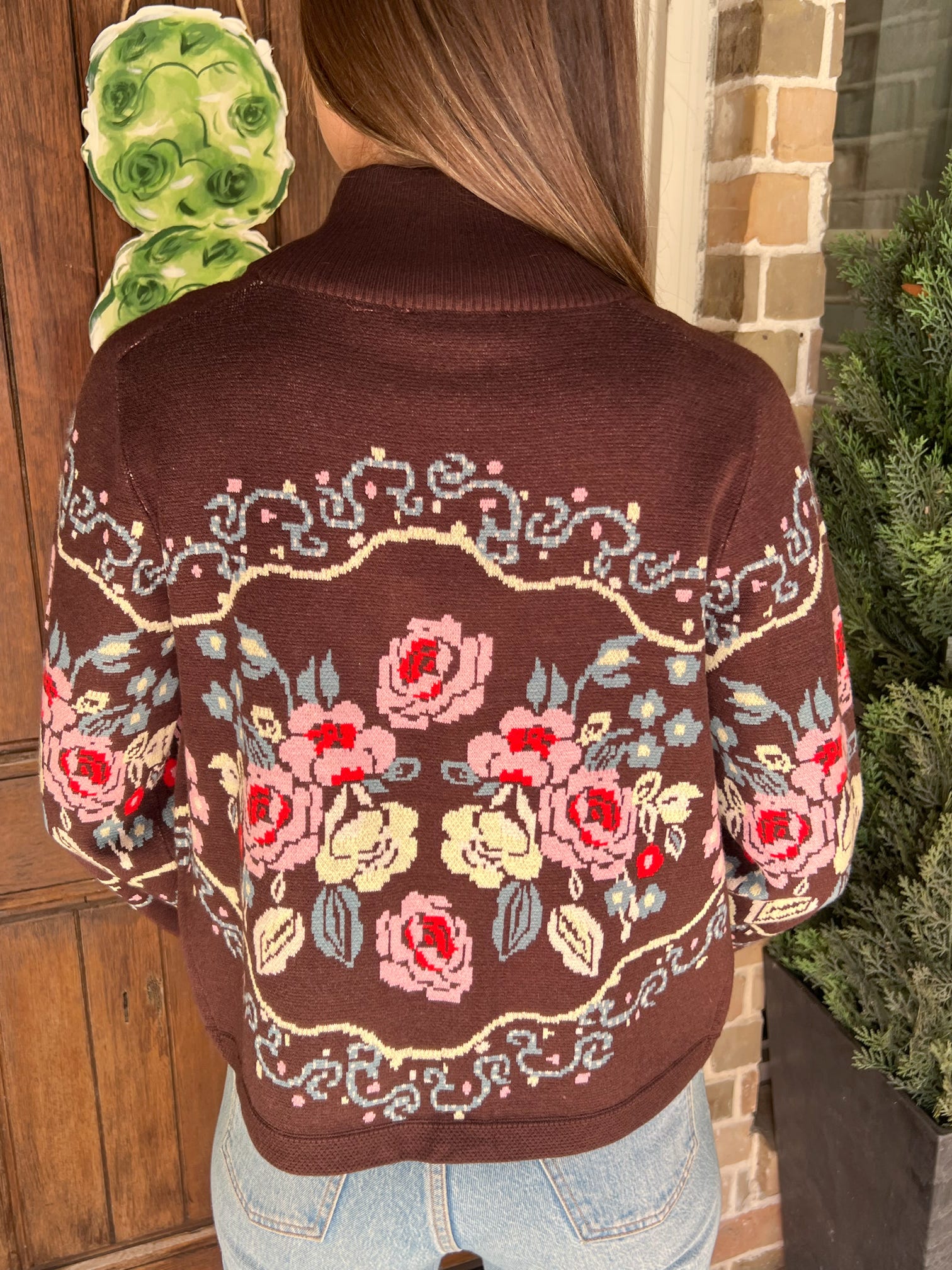 Photo of the back of a brown cardigan with a floral pattern