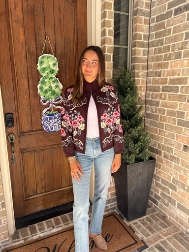 Woman wearing a brown cardigan with pink and beige flowers all over