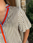 Another up close photo of a cream and khaki striped short sleeve blouse with an orange and blue stripe around the collar and down the front 