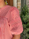 Up close photo of the bubble sleeve of the orange and white striped blouse