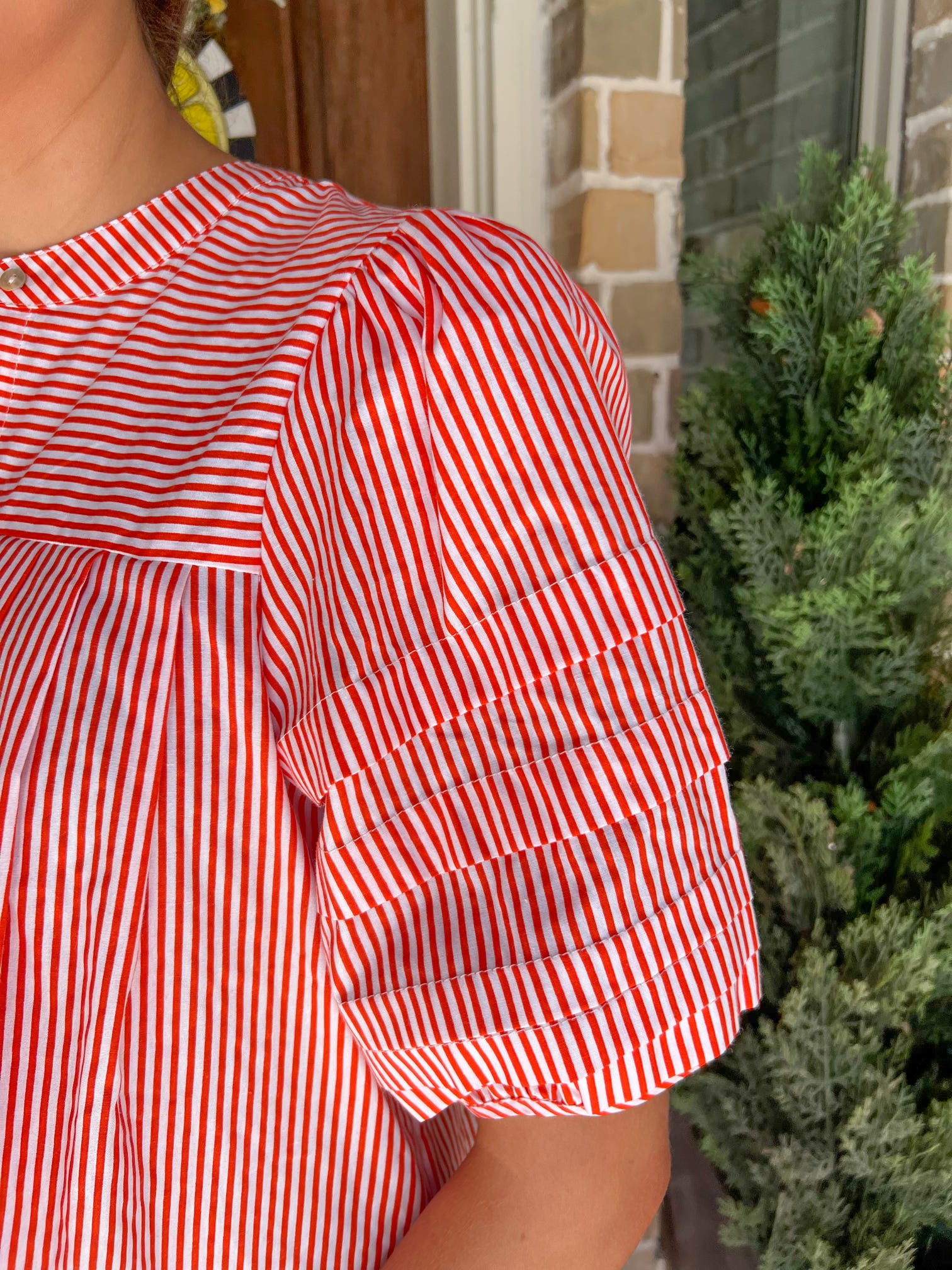 Up close photo of the bubble sleeve of the orange and white striped blouse