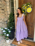 Wma modeling a lavender smocked midi dress that ties at the shoulders