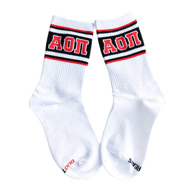 A pair of white crew socks with black and red stripes at the cuff, featuring the Greek letters 'ΑΟΠ' in red on the black background. 