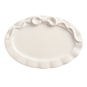 White decorative plate with a decorative edge and bow on a white background