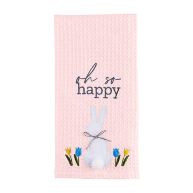 Photo of our light pink kitchen towel saying Oh So Happy with a white applique bunny and tulip flowers on it