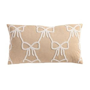 Beige pillow with white bow pattern on a beige background