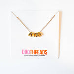 A gold chain necklace with a 'AOPi' initial pendant displayed on a white card. The card features the brand name 'DUOTHREADS' printed in pink and orange at the bottom.