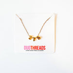 A gold chain necklace with a  'ZTA' pendant, displayed on a white card with the brand name 'DUOTHREADS' printed in pink and red.