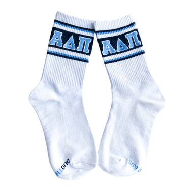 A pair of white crew socks with navy and light blue stripes at the cuff, featuring the Greek letters Alpha Delta Pi (ΑΔΛ) in light blue on the front. The word 'DUO' is printed in light blue on the toes.
