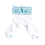 A pair of white crew socks with a bold turquoise and white 'ZTA' logo across the ribbed cuffs, displayed against a clean white background.