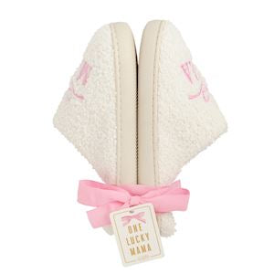 Pair of white slippers with rubber bottom that says Mama with a bow on the top in light pink
