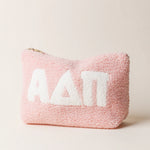 Pink fluffy pouch with white sorority letters saying ADPi on a light beige background
