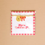 Gold bead bracelet with Alpha Omicron Pi charm and a red bow charm