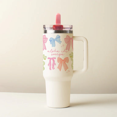 Tumbler with colorful bow designs on a beige background saying Alpha Chi Omega