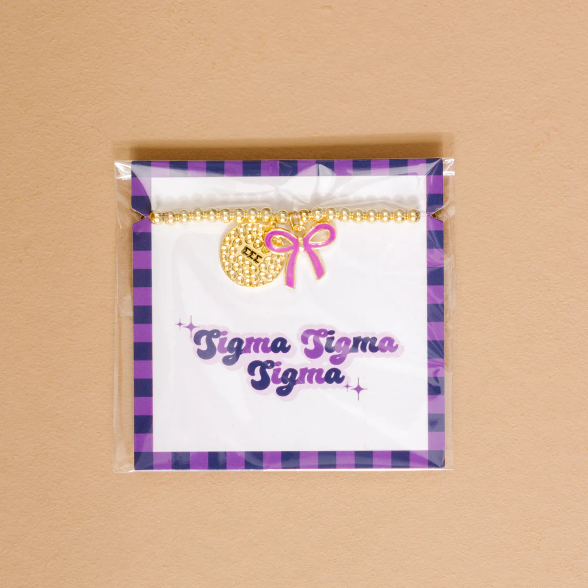 Gold bead bracelet with Sigma Sigma Sigma charm and a lavender bow charm