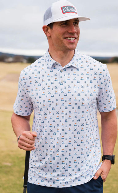 Photo of a man modeling our performance white short sleeve polo featuring a fun print of a golf ball, cart, and putting green in shades of blue.