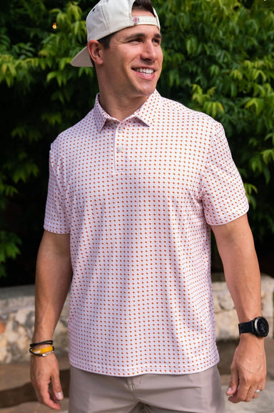 Man modeling the front of our white short sleeve polo with an all over pattern of orange shapes of the state of Texas