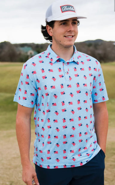 Man modeling a light blue short sleeve polo with small American flags all over