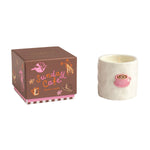 Candle with a pink design and decorative box labeled 'Sunday Cafe' on a white background