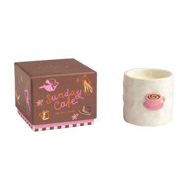 Candle with a pink design and decorative box labeled 'Sunday Cafe' on a white background