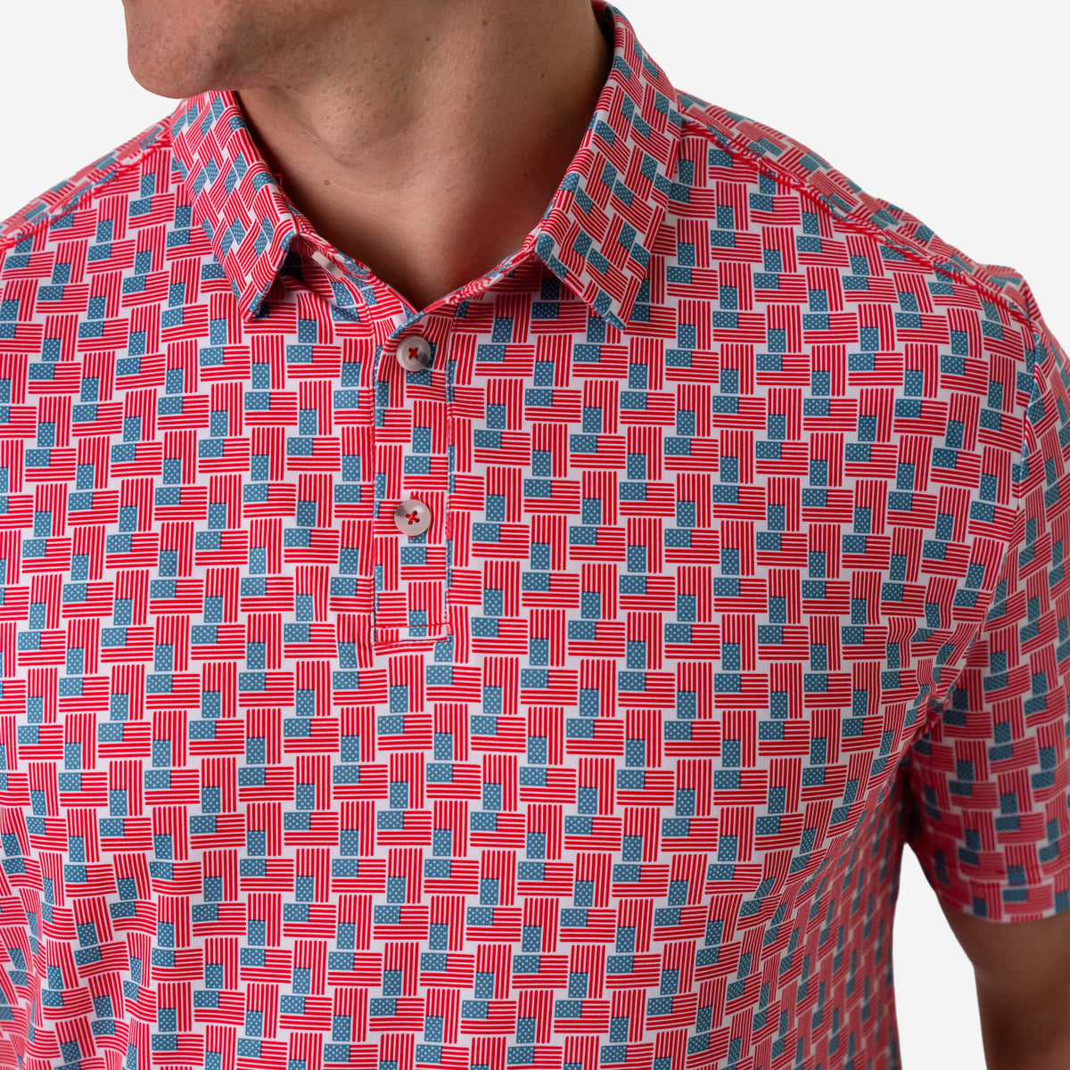 Up close photo of an American Flag patterned short sleeve polo shirt with a white background.