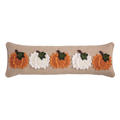 Decorative pillow with crocheted pumpkins on a beige background