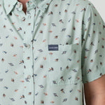 Light green button down shirt with small pattern of fishing lures and Burlebo label on a person
