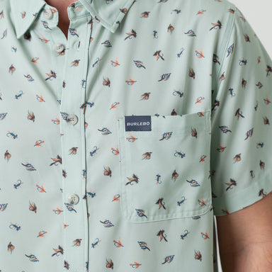 Light green button down shirt with small pattern of fishing lures and Burlebo label on a person