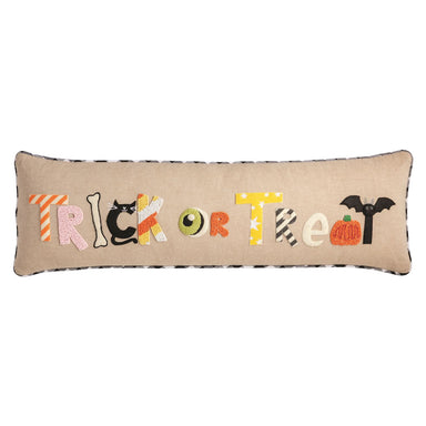 Decorative pillow with 'Trick or Treat' text and Halloween-themed letters on a beige background