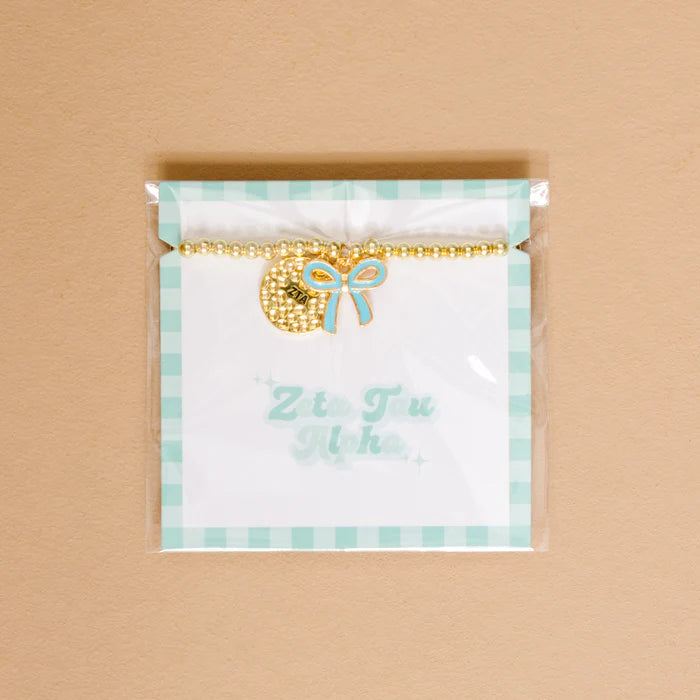 Gold bead bracelet with Zeta Tau Alpha charm and a turqouise bow charm
