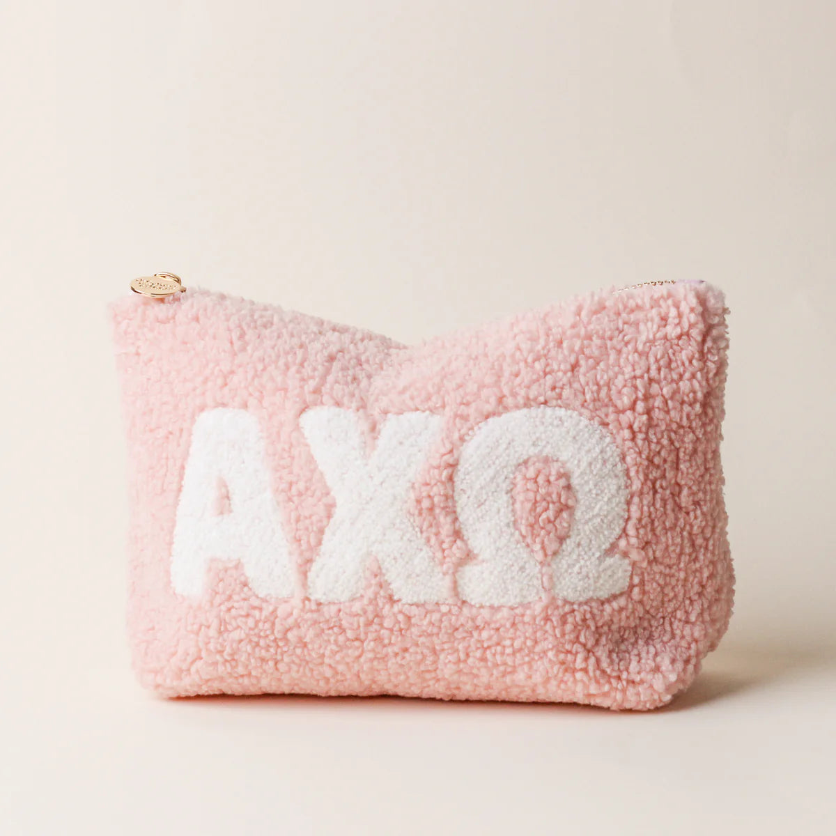 Pink fluffy pouch with white sorority letters saying AXO on a light pink background