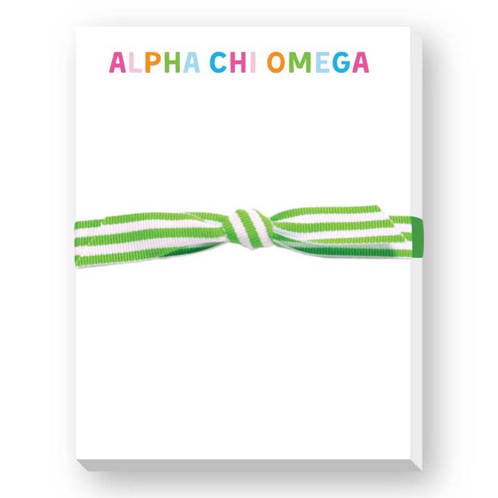 A white rectangular box or package with the words “ALPHA CHI OMEGA” printed across the top in multicolored letters, tied with a green and white striped ribbon bow, shown on a white background.