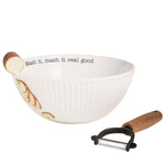 A white ribbed ceramic bowl with a wooden peeler and a printed potato design, shown on a plain white background. The inside of the bowl reads 'Mash it, mash it real good'.